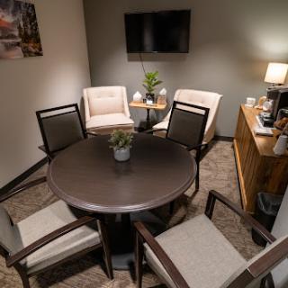 A cozy meeting space with a round table and comfortable chairs, perfect for discussions.