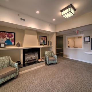 A cozy lobby with a fireplace, seating area, and artwork on the walls.