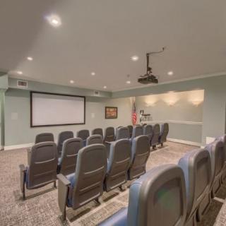 A small theater room with rows of seating and a projector screen.