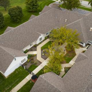 An aerial view of a building complex featuring a central courtyard with trees and walkways.