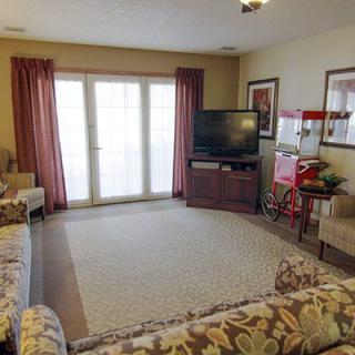 A cozy living room featuring a sofa set, television, and popcorn machine.