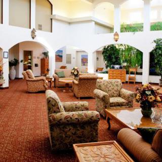 A spacious and well-furnished lobby area with comfortable seating and decorative plants.