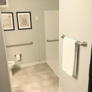 A clean, well-lit bathroom with simple decor and a towel rack.