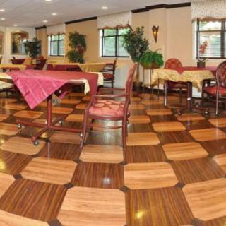 A spacious dining area with a checkered floor pattern, furnished with tables and chairs.