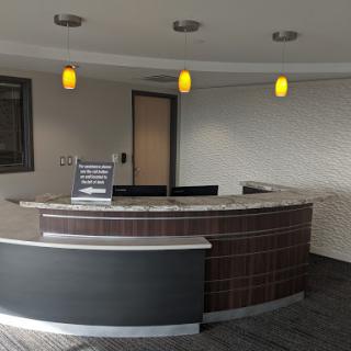 A modern office reception area with sleek furniture and ambient lighting.