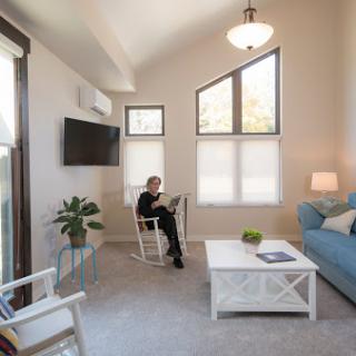 A cozy living room featuring modern furniture, ample natural light, and a comfortable reading nook.