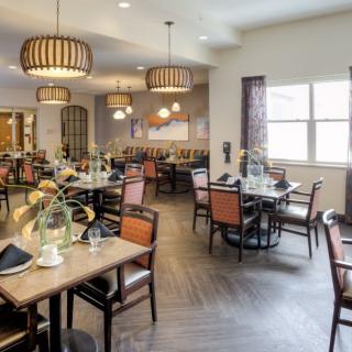 A modern dining area with neatly arranged tables and stylish lighting fixtures.