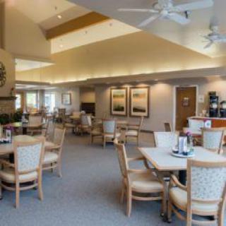 A spacious and well-lit dining area with neatly arranged tables and chairs.