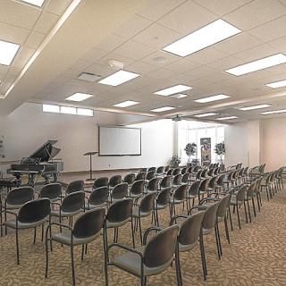 An empty conference room with rows of chairs and a presentation setup.