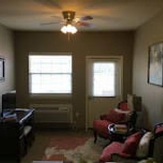 A cozy living room with comfortable seating and a ceiling fan.