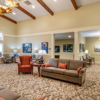 A cozy living room with sofas, armchairs, and warm decor.