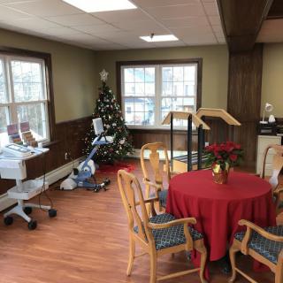 A cozy room with a decorated Christmas tree and a table set for gathering.