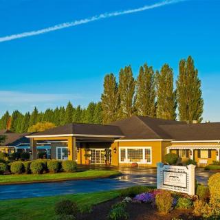 A healthcare facility surrounded by well-maintained landscaping on a clear day.