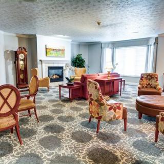 A cozy living room with a mix of seating options, a fireplace, and a grandfather clock.