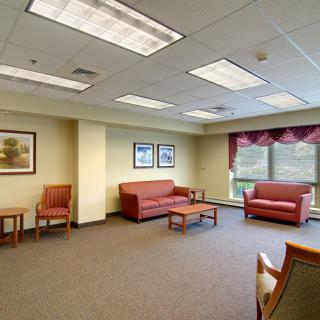 A bright and spacious waiting room with sofas, chairs, and a coffee table.