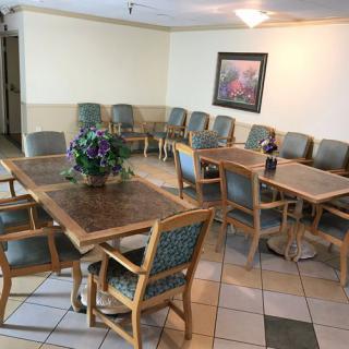 An indoor waiting room with several chairs and tables arranged neatly.