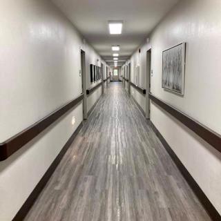 A long, symmetrical indoor hallway with closed doors on both sides.