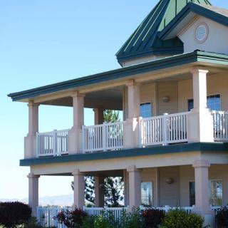 A two-story house with balconies and a green roof.