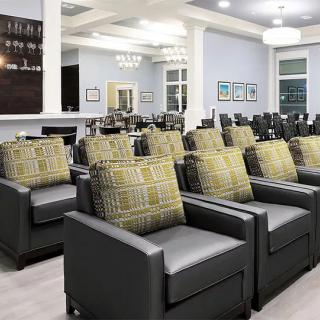 A modern lounge area with rows of comfortable chairs and decorative cushions.