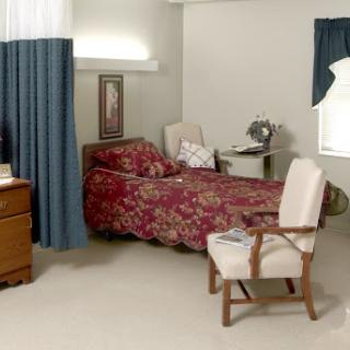 A cozy bedroom featuring floral bedding, a desk, and comfortable seating.