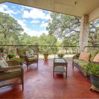 A cozy porch with comfortable seating and a view of lush trees.