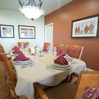 A neatly arranged dining table with elegant place settings and decorative elements in a cozy dining room.