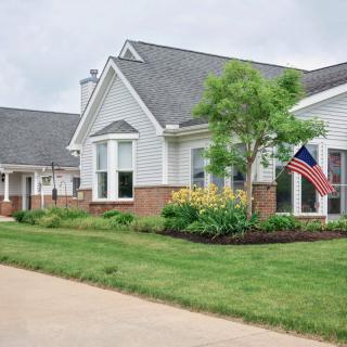 A suburban residential house with a well-maintained yard and an American flag.
