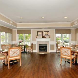 Spacious dining area with wooden floors and a central fireplace.