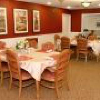 A cozy dining area with set tables and comfortable seating.