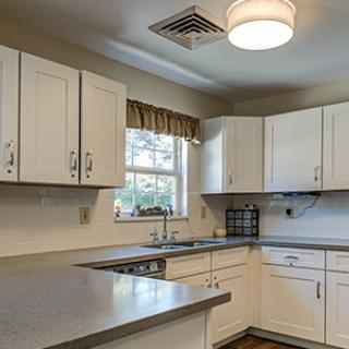 A modern kitchen with white cabinets and a sleek countertop.