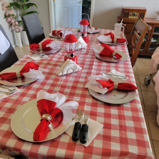 An elegant dining setup with a red and white theme, featuring neatly arranged plates and decorative napkins.