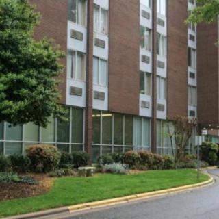 Exterior view of a residential apartment building with landscaped surroundings.