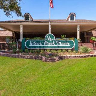 The entrance to Silver Creek Ranch, featuring a welcoming sign and lush green surroundings.