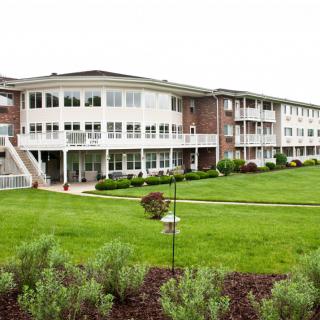 A well-maintained apartment complex surrounded by green lawns and landscaping.