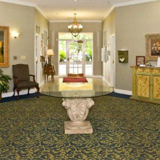 A well-decorated lobby with a central glass table and surrounding artwork.