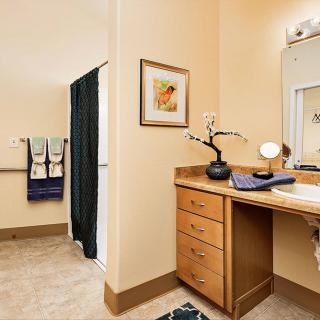 A modern bathroom with a vanity area featuring neatly arranged towels and decorative accents.