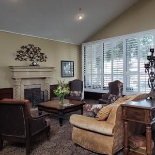 A cozy living room with a fireplace, armchairs, and a coffee table.