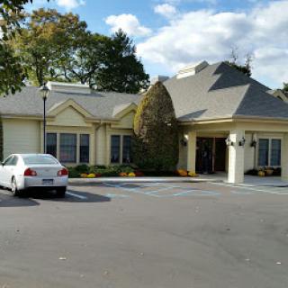 A charming residential building with a well-maintained exterior and surrounding greenery.