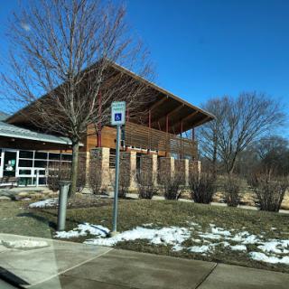 A modern architectural building with a large overhanging roof, situated in a winter landscape.