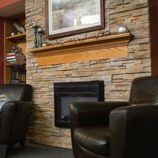 A cozy living room with a stone fireplace and comfortable armchairs.