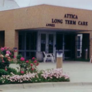 Entrance of Attica Long Term Care facility with colorful flowers in front.