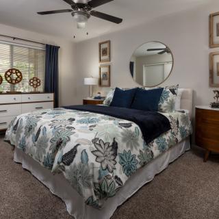 A cozy, well-decorated bedroom with a floral bedspread and modern furnishings.