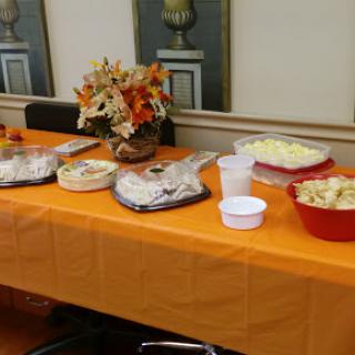 A beautifully arranged buffet table featuring a variety of dishes, adorned with autumn-themed decorations.