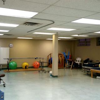 A spacious physical therapy room with fitness balls and rehabilitation equipment.