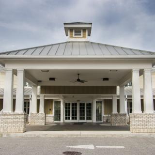 A symmetrical building entrance with prominent columns and a pitched roof.
