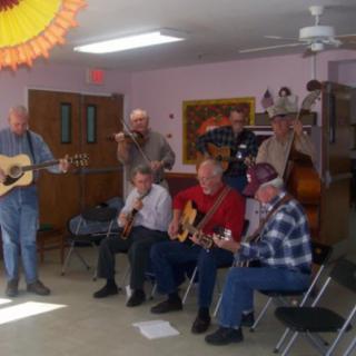 A group of musicians performing indoors with guitars.
