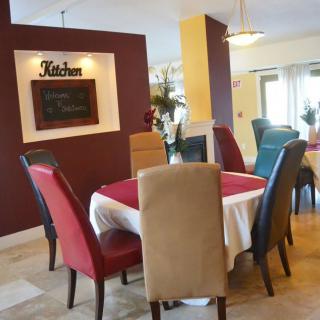 A cozy dining area with a set table and colorful chairs.