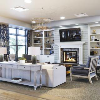 A modern living room features a cozy fireplace, elegant furniture, and ample natural light.
