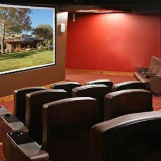 A luxurious home theater featuring comfortable seating and a large projection screen.