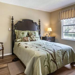 A cozy bedroom with a decorative bedspread and elegant furnishings.